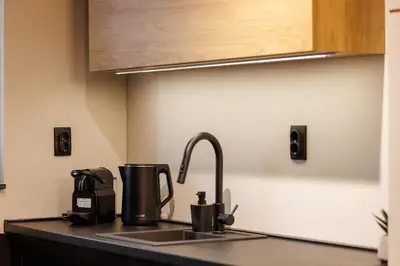a kitchen counter with a sink with a coffee maker at T & T Apartman - 2 bedrooms in Pirot