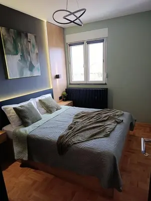 a bedroom with a bed and a ceiling fan at T & T Apartman - 2 bedrooms in Pirot