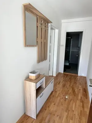 a room with a dresser and a mirror on a wall at Apartman Ramonda in Niš