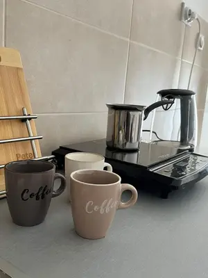 three coffee cups sitting on a counter in a kitchen at Apartman Ramonda in Niš