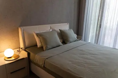 a bedroom with a bed with a lamp and a window at 501 View Vrnjacka Banja in Vrnjačka Banja