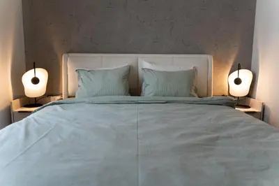 a bedroom with a large bed with two lamps at 501 View Vrnjacka Banja in Vrnjačka Banja