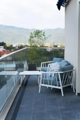 a patio with two chairs and a table on a balcony at 501 View Vrnjacka Banja in Vrnjačka Banja