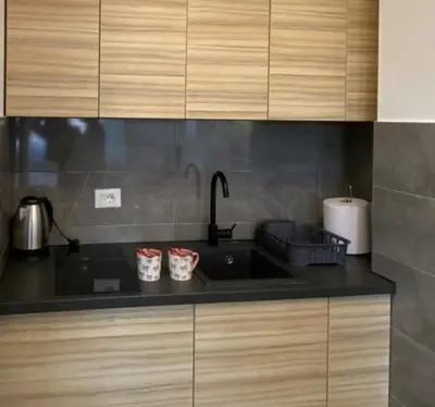 a kitchen counter with a sink and two cups at M&A apartman in Jagodina