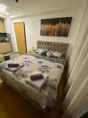 a bedroom with a large bed with two candles on it at M&A apartman in Jagodina