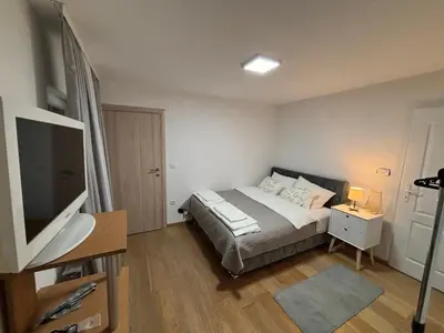 a bedroom with a bed and a flat screen tv at Royal Homolje Apartments in Žagubica