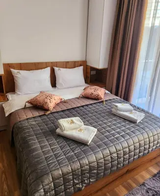 a bedroom with a bed with two towels on it at Gali lux apartmani in Kopaonik