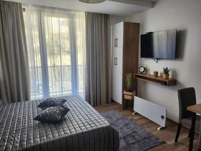 a bedroom with a bed with pillows and a television at Gali lux apartmani in Kopaonik
