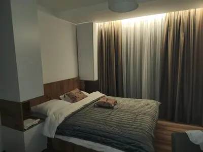 a bedroom with a bed and a window with curtains at Gali lux apartmani in Kopaonik