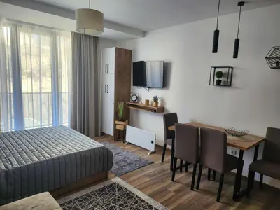 a bedroom with a bed and a table and a dining room at Gali lux apartmani in Kopaonik
