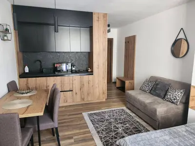 a living room with a table and a couch at Gali lux apartmani in Kopaonik