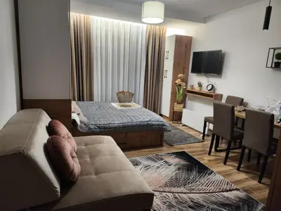 a living room with a couch and a dining room at Gali lux apartmani in Kopaonik