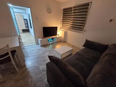 a living room with a couch and a flat screen tv at Stan na dan Bor Apartman in Bor