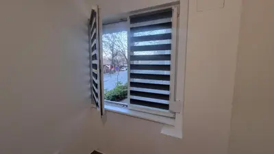 a window in a white wall with a window sill at Stan na dan Bor Apartman in Bor