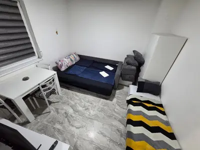 a small room with a bed and a table at Stan na dan Bor Apartman in Bor