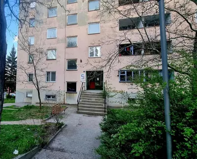 a large pink building with a red door at Stan na dan Bor Apartman in Bor