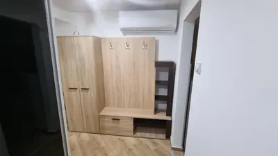 a closet in a room with wooden cabinets at Stan na dan Bor Apartman in Bor