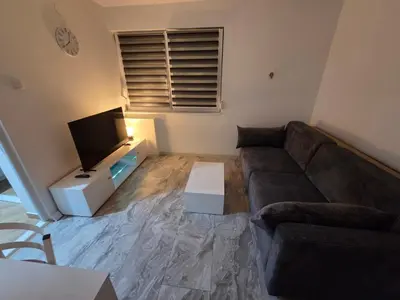 a living room with a couch and a flat screen tv at Stan na dan Bor Apartman in Bor