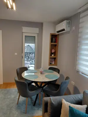 a dining room with a table and chairs in a room at Apartman Hedon in Vrnjačka Banja