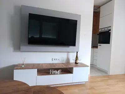 a living room with a tv on a wall at Apartman Hedon in Vrnjačka Banja