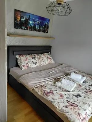 a bed in a bedroom with avertisementatronatronatronstrationstrationstration at Apartman Hedon in Vrnjačka Banja