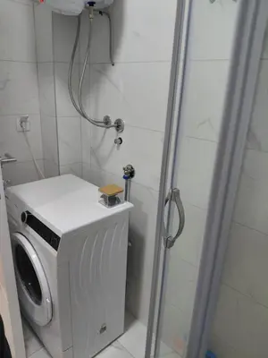 a shower with a washing machine in a bathroom at Apartman Hedon in Vrnjačka Banja