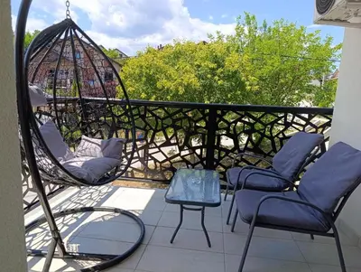 a balcony with two chairs and a swing at Apartman Hedon in Vrnjačka Banja