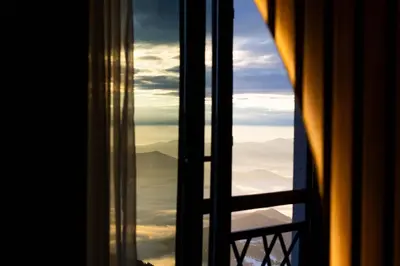 a window with a view of the mountains and clouds at Luxe Horizon & Spa Apartments Kopaonik in Kopaonik