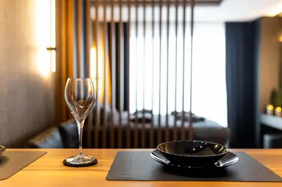 a table with a plate and a wine glass on it at Luxe Horizon & Spa Apartments Kopaonik in Kopaonik