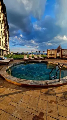 a small swimming pool with lounge chairs around it at Luxe Horizon & Spa Apartments Kopaonik in Kopaonik