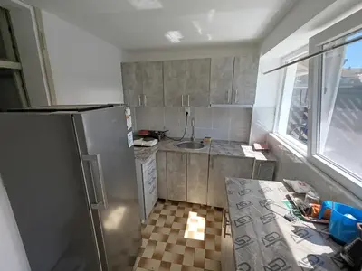 a small kitchen with a refrigerator and a window at Apartman Marina i Sobe Luka in Bukorovac