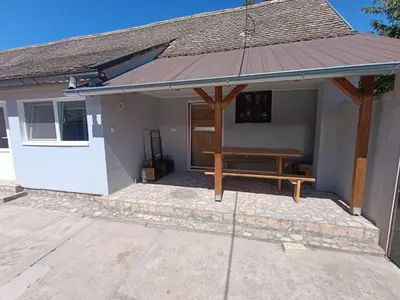 a pavilion with a bench in front of a house at Apartman Marina i Sobe Luka in Bukorovac