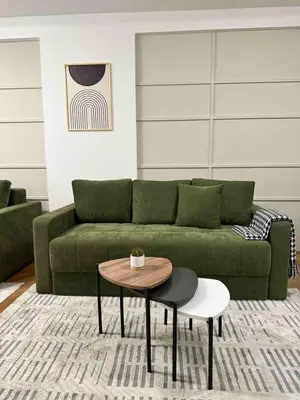 a living room with a green couch and a table at Green Oasis in Vrnjačka Banja
