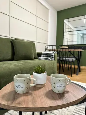 two coffee cups sitting on a table in a living room at Green Oasis in Vrnjačka Banja