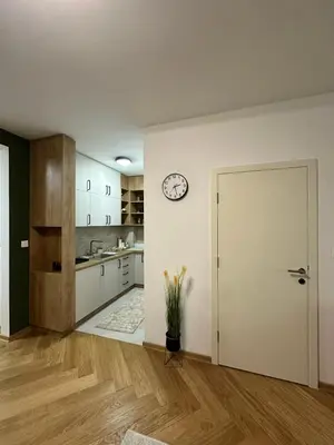 an empty kitchen with a clock on the wall at Green Oasis in Vrnjačka Banja