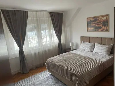 a bedroom with a bed and a large window at Panorama centar, free parking in Niš