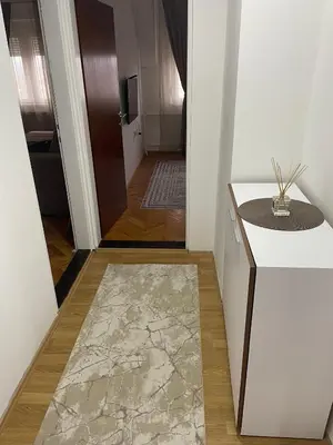 a hallway with a white counter and a door with a rug at Panorama centar, free parking in Niš