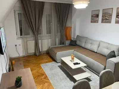 a living room with a couch and a table at Panorama centar, free parking in Niš