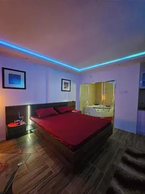 a bedroom with a large bed with a red comforter at Heaven in Niš