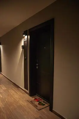 an empty hallway with a black door and a door mat at VujSki - Gondola Apartman in Brzeće