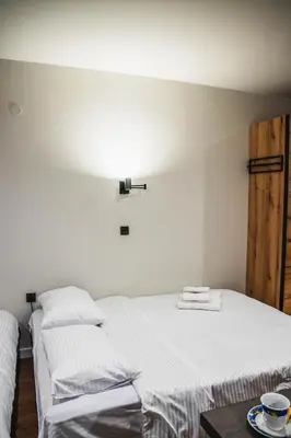 a bedroom with two beds and a table at VujSki - Gondola Apartman in Brzeće