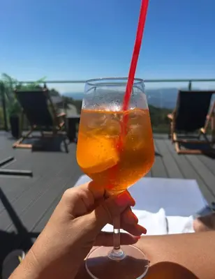 a person holding a drink with a red straw at Milmari Bonita Nlux87 in Kopaonik