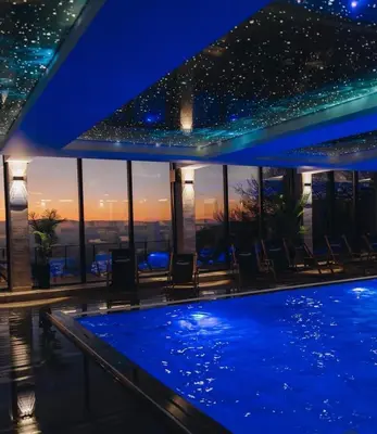 a swimming pool at night with a view of the city at Milmari Bonita Nlux87 in Kopaonik
