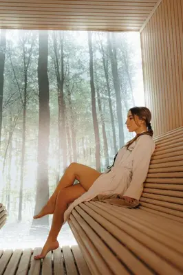 a woman sitting on a bench in front of a window at Milmari Bonita Nlux87 in Kopaonik