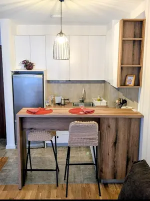 a kitchen with a wooden counter with two chairs at Mimi -Green Hill in Soko Banja