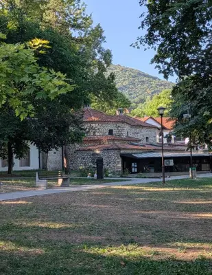 a large stone building in a park with trees at Mimi -Green Hill in Soko Banja