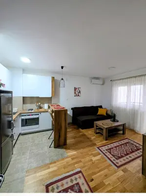 a kitchen and living room with a couch and a table at Mimi -Green Hill in Soko Banja