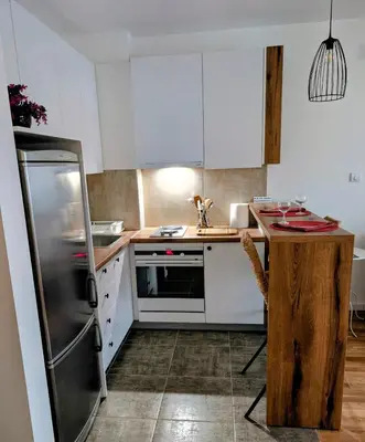 a kitchen with white cabinets and a stainless steel refrigerator at Mimi -Green Hill in Soko Banja
