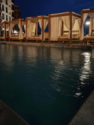 a row of chairs sitting next to a body of water at Alpina Lux in Kopaonik