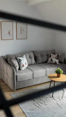 a gray couch in a living room with a table at Lawa 22 in Kopaonik